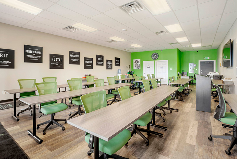 Training classroom setup at Listing Leaders Northwest School of Real Estate with desks, chairs, and teaching podium.