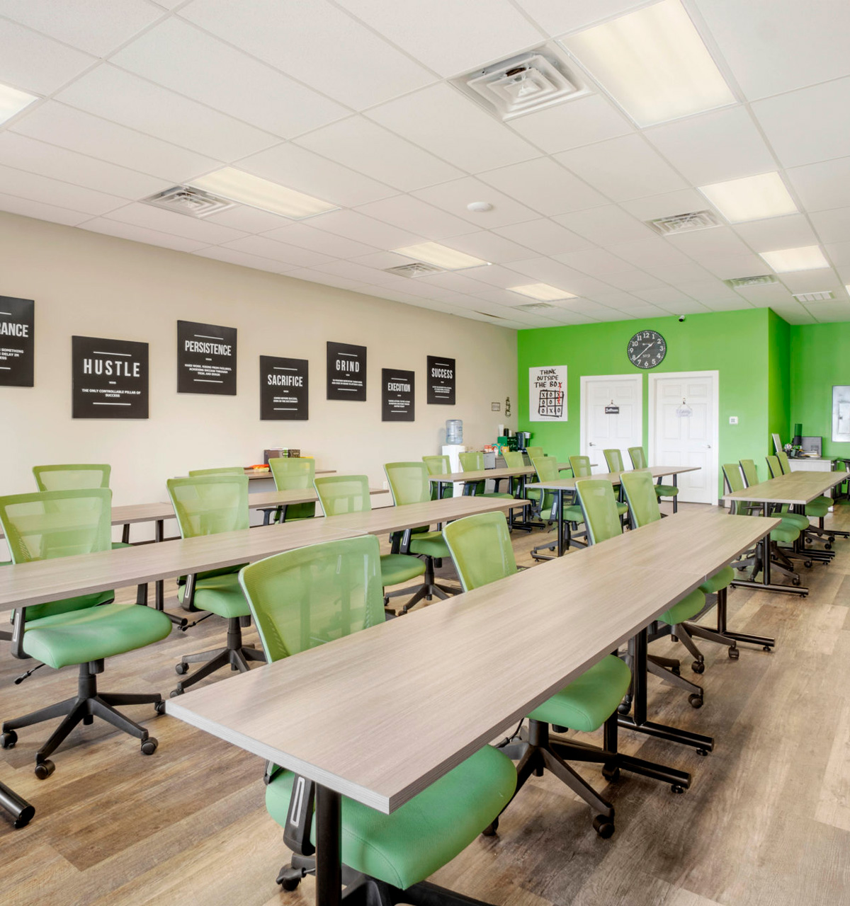 Real estate classroom at Listing Leaders Northwest featuring bright green chairs, work tables, and motivational decor. Real estate classroom at Listing Leaders Northwest featuring bright green chairs, work tables, and motivational decor.